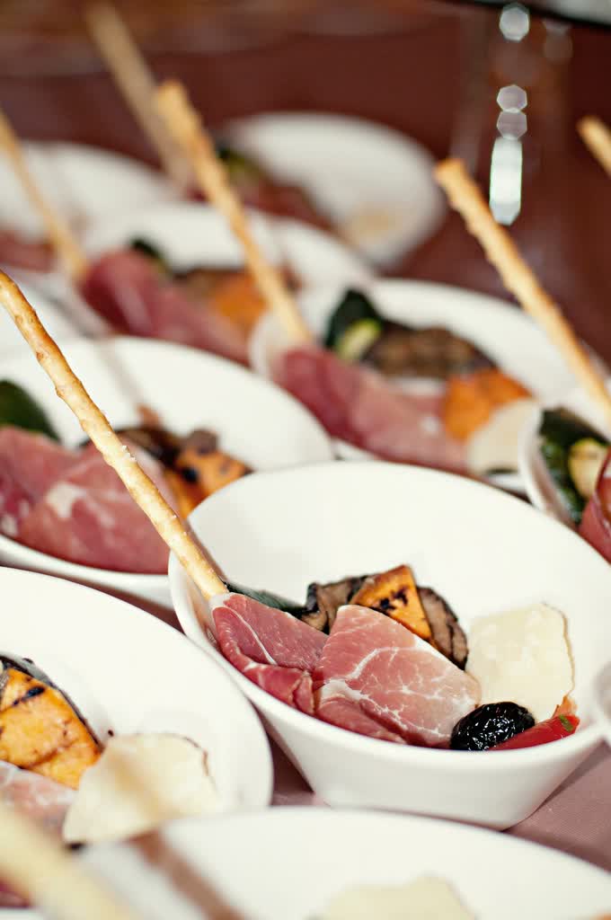 Ham, olives and cold cuts on a buffet table.