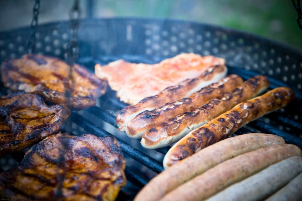 Sausages and meat on the grill, close-up.